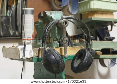 Listening to music at work concept, dirty old headphones in a carpenter\'s work place