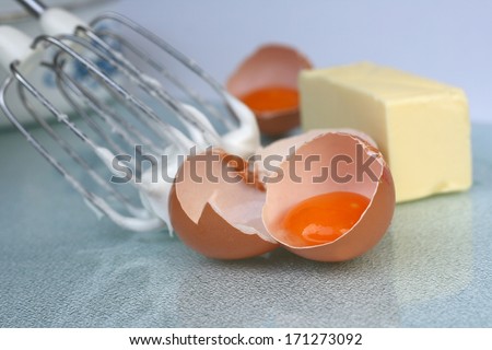 Baking concept, split eggs with egg yolk and butter, mixer with beaten egg whites
