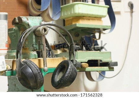Listening to music at work concept, dirty old headphones in a carpenter\'s work place