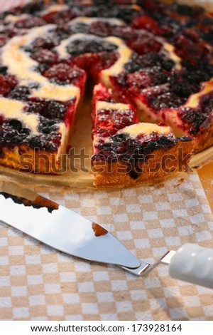 Raspberry, blueberry and blackberry pie with curd and milk cream and powdered sugar