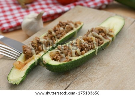 Zucchini filled with minced meat, garlic, onion, tomatoes and covered with cheese. Baked in an oven.