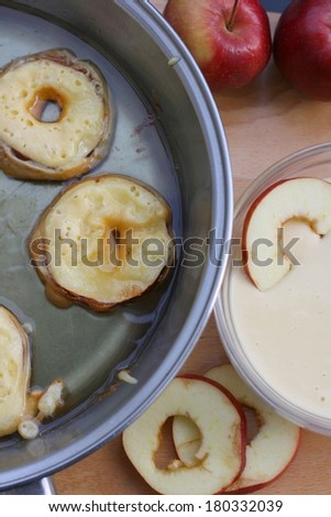 Making apple fritters with pancake batter, apple slices and oil
