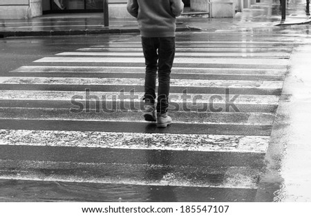 Pedestrian crosswalk on a rainy day, walking in the city in rain. Black and white