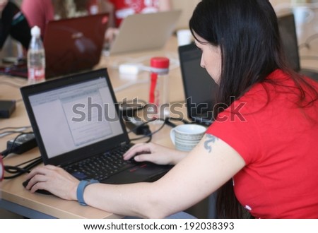 Woman on a laptop computer, working with a group of female university students of computer science, programming code