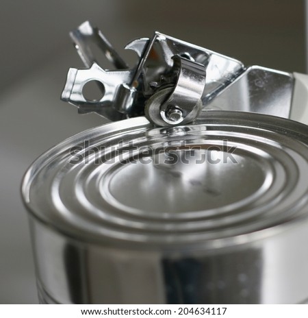 Tin opener opening a can in a kitchen