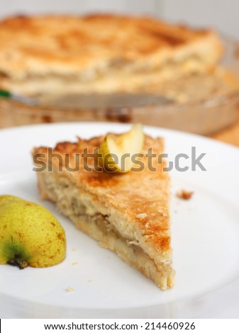 Piece of fresh homemade pear pie with fresh pear slice
