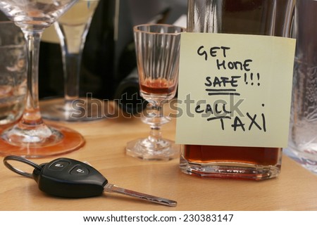 Car keys on the table full of empty glasses, bottles at party, don\'t drink and drive concept, post it note for taxi