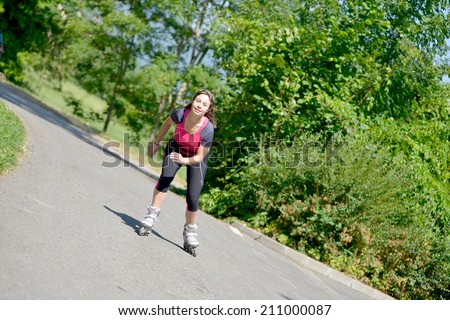 pretty young woman doing roller skate on a track in the French Alps