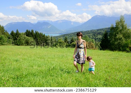 a beautiful mother and daughter walking in the mountains