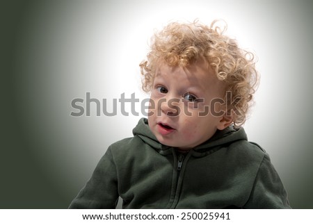 portrait of a little boy of 3 years with a green coat