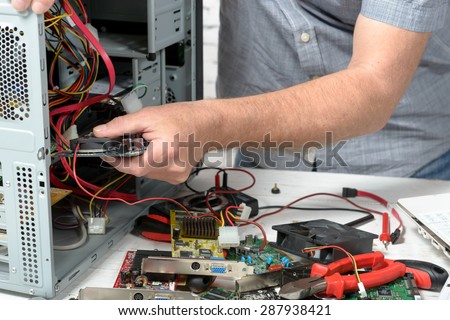 a technician repairing a computer with different tools