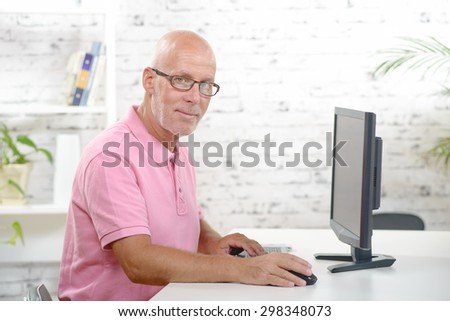 a businessman with a pink polo shirt works in his office