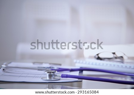 Purple stethoscope on the glass desk