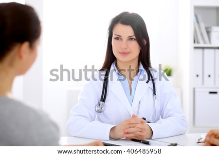 Brunette female doctor talking to patient in the hospital