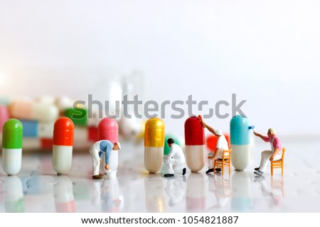 Miniature people: Workers  team brush painting Medicinal capsules. Healthcare, Medical  and business concept.