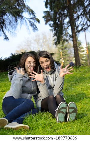 Two beautiful young woman expressing positivity, agreement and excitement in a park