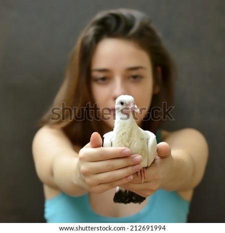 Young woman helping rescue a baby pidgeon. Save a pigeon.