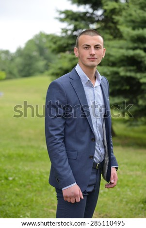 Handsome formally dressed young man standing outside