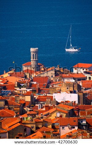 Roofs of a typical town in Southern Europe and a sailing boat