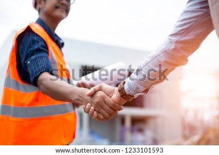 Engineer man handshake with asian business after finishing up meeting, partnership, teamwork, community, connection industriall and investment concept