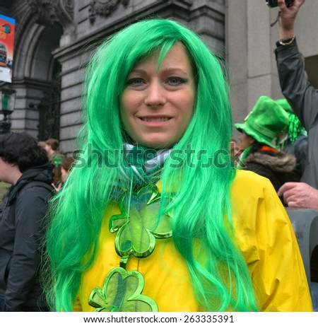 DUBLIN, IRELAND - MARCH 17: An unidentified, costumed female spectator wearing a green wig and large shamrock necklace during the St. Patrick\'s Day Parade on March 17, 2015 in Dublin, Ireland.