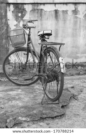 old bicycle parked in front of a wall.