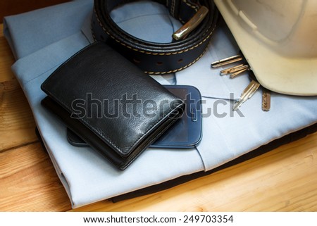workwear, boots and wallet and mobile on wooden table.