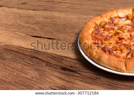 pizza pepperoni meat and sausace white plate on wooden table texture background