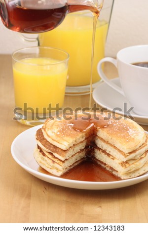 exquisite pancakes with syrup  orange juice and coffe perfect balanced breakfast