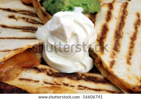 Mexican quesadilla made with cheddar, mozzarella cheese,beef   and fresh guacamole and sour cream