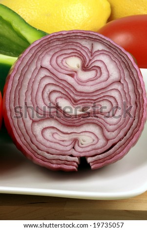 red organic onion with other fresh veggies around