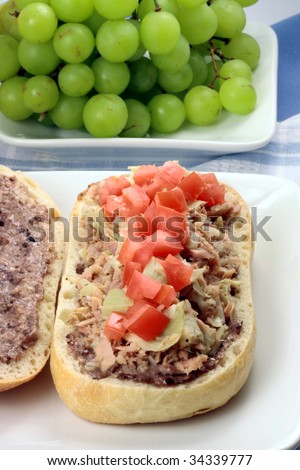 Fresh healthy mediterranean tuna artichokes and olive sandwich with lots of fresh organic fruits
