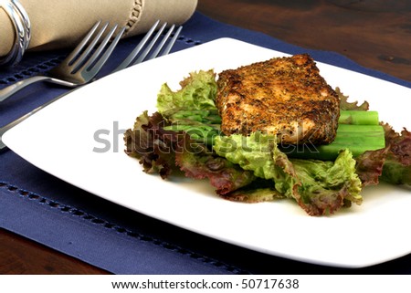 delicious grilled sea bass, seasoned with fine spices with asparagus and lettuce bed