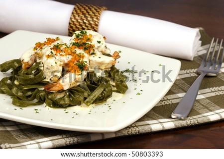 Gourmet exquisite spinach fettuccine pasta with prawns on fancy dinner table