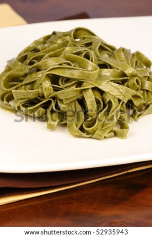 Gourmet exquisite spinach fettuccine pasta on fancy dinner table