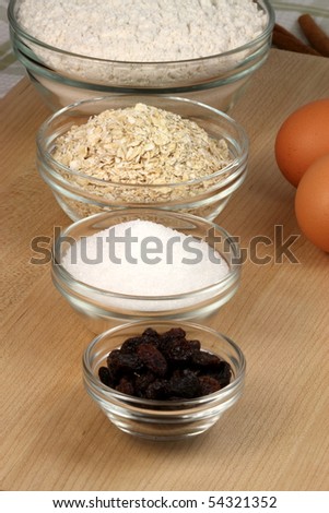 oatmeal and raisins cookies  ingredients and kitchen utensils on wood cutting board