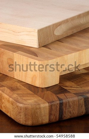 fine wood cutting boards one on top of each other over rustic wood table