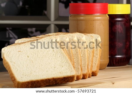 peanut butter and jelly sandwich ingredients on preparation wood board  with jars and bread