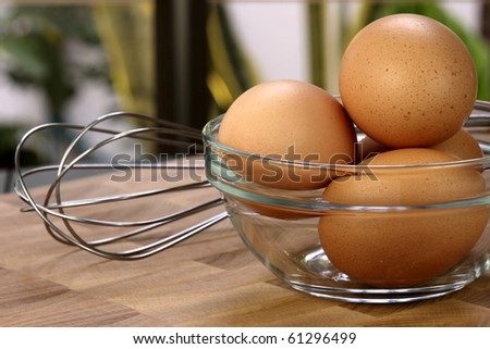 organic raw eggs on fancy kitchen dishware, one of the most used food ingredient with whisk on side