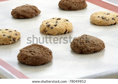 Fresh baked Stack of warm chocolate chips cookies and chocolate cookies on baking tray shallow DOF