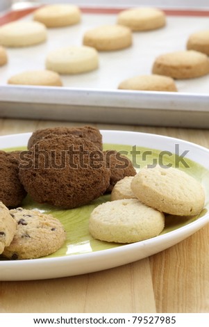 Fresh baked Stack of warm chocolate chips cookies, chocolate cookies and shortbread cookies shallow DOF