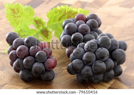 fresh delicious and healthy organic concord grapes on fine wood cutting board