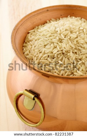raw brown rice used to make healthy and delicious recipes, on copper pot
