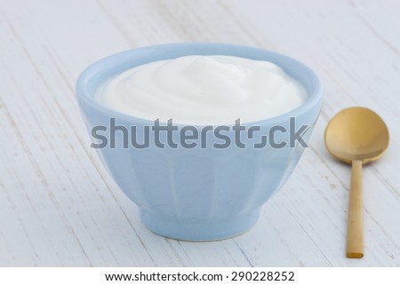 Delicious, nutritious and healthy fresh plain greek  yogurt on antique wood table