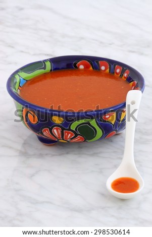 Artisan hot taco sauce in vintage talavera bowl, with a delicious fresh hot flavor,  on vintage carrara marble table.