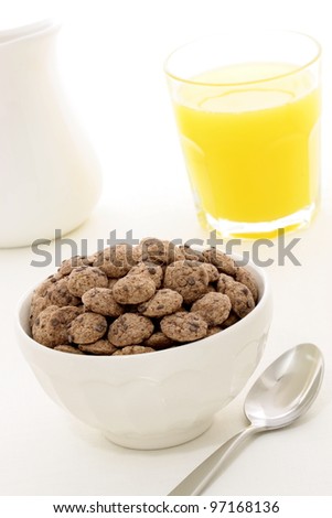 delicious and nutritious whole wheat chocolate chips cookies cereal with milk and orange juice, flavorful, funny and healthy addition to kids breakfast