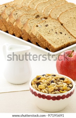 delicious breakfast with whole grain bread,fresh red apple and a healthy bowl of muesli cereal.