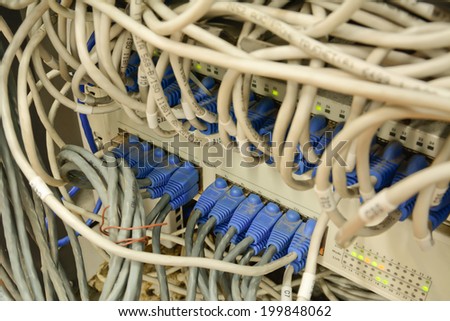 close-up of mess ethernet cables connected to computer  internet server with many dust and dirty in the bottom; lack of maintenance