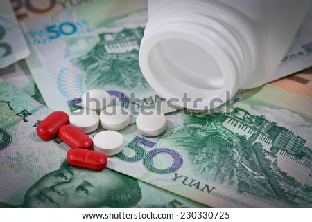tablets on Yuan banknotes (renminbi),  for costs of medications and health insurance concept ;  with vignette filter.