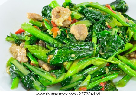 closeup of  kale vegetable fried with oil and pork ; selective focus